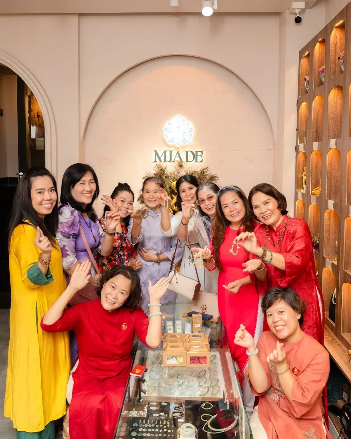Người phụ nữ váy xanh đeo chuỗi ngọc phỉ thúy lục, cầm quạt, phông gỗ ấm trầm